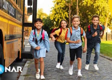 Image of happy school children exiting their school bus