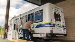 A paratransit vehicle being fueled