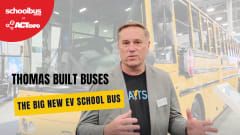 Mark Childers of Thomas Built Buses stands in front of a large yellow electric school bus at ACT Expo while discussing the company’s new Type D EV school bus platform. Overlay text reads “The Big New EV School Bus” with School Bus Fleet at ACT Expo branding.