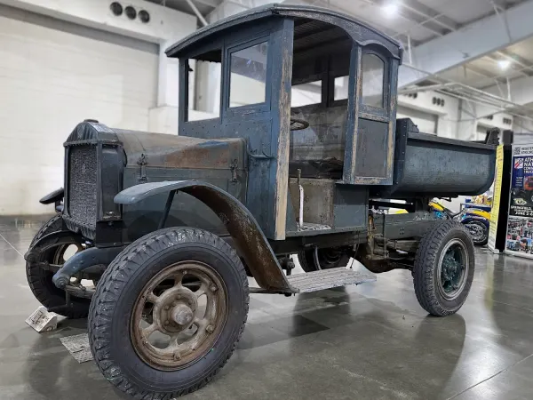 A blue-gray truck from the 1920s on display indoors