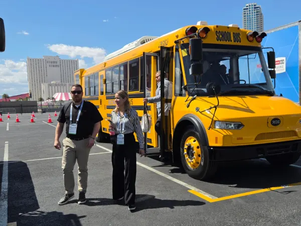 ACT Expo attendees board a RIDE electric school bus during a ride-and-drive demonstration outside the Las Vegas convention center.