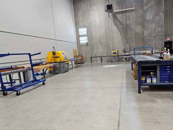 Industrial cutting station used to size aluminum flooring components at AMF Bruns facility