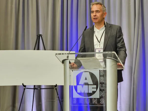 Peter Haarhuis stands at an AMF Bruns podium while speaking.