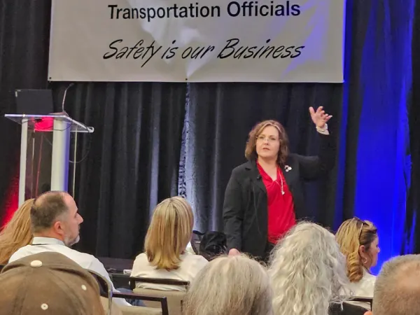 Kerri Gardner addresses attendees from the stage under a CASTO banner reading “Safety Is Our Business,” engaging the audience during a session.