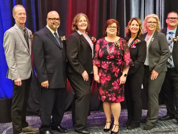 Members of the CASTO executive committee pose together on stage in formal attire following the business meeting and awards ceremony.