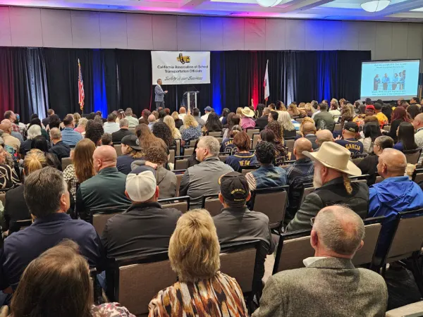 Wide view of a packed ballroom at the CASTO 2026 conference as a keynote speaker presents on stage beneath a “Safety Is Our Business” banner, with attendees seated and listening.