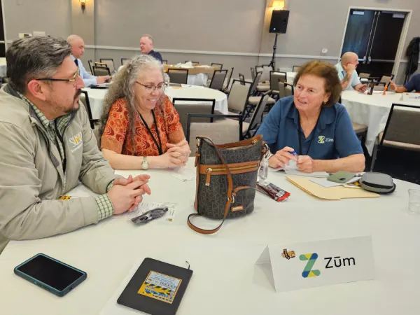 Attendees converse at a round table during a networking meet-and-greet session sponsored by Zum.