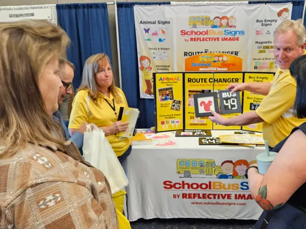 three attendees talk with a vendor during a trade show