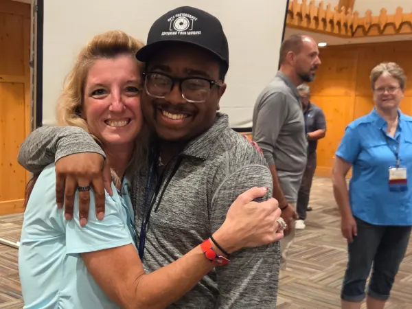 MAPT Executive Director Katrina Morris hugs Nashawn Craig as attendees mingle following the conclusion of the conference.