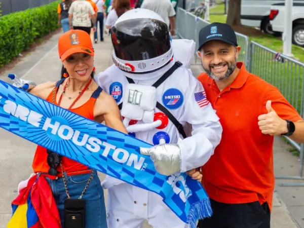 Two World Cup goers post with a Houston Metro METROnaut.