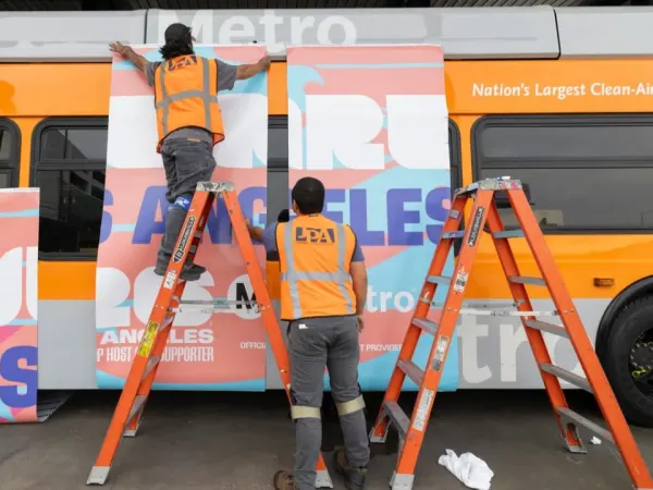 Crews apply World Cup branding to a Los Angeles Metro bus as the region welcomed tournament visitors.