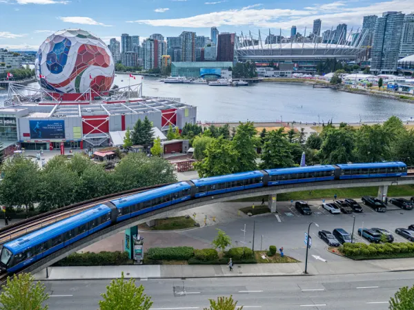 A TransLink train goes by a large FIFA World Cup soccer ball structure.
