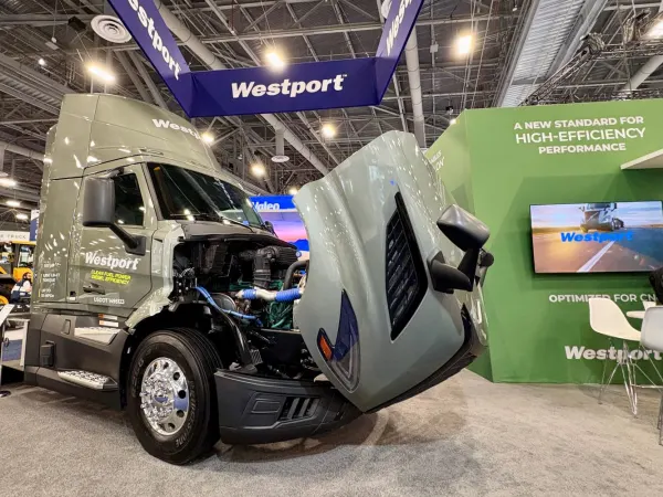 Gray truck with hood open and Westport banners above on show floor