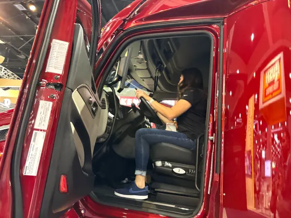 Woman behind wheel of red Peterbilt truck
