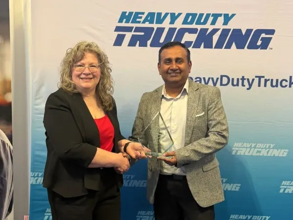 Man and woman shaking hands with Top 20 trophy between them
