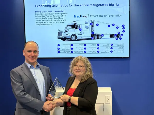 Man and woman shaking hands with Top 20 trophy between them
