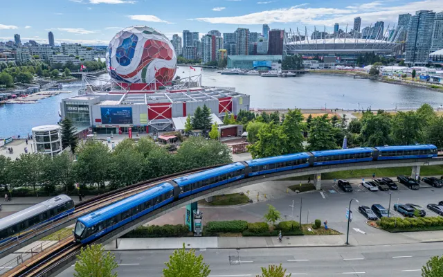 A TransLink train goes by a large FIFA World Cup soccer ball structure.
