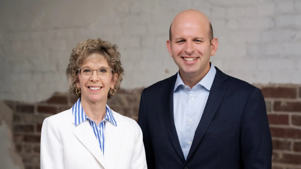 ArcBest's Judy McReynolds in white blazer next to Seth Runser in blue blazer.