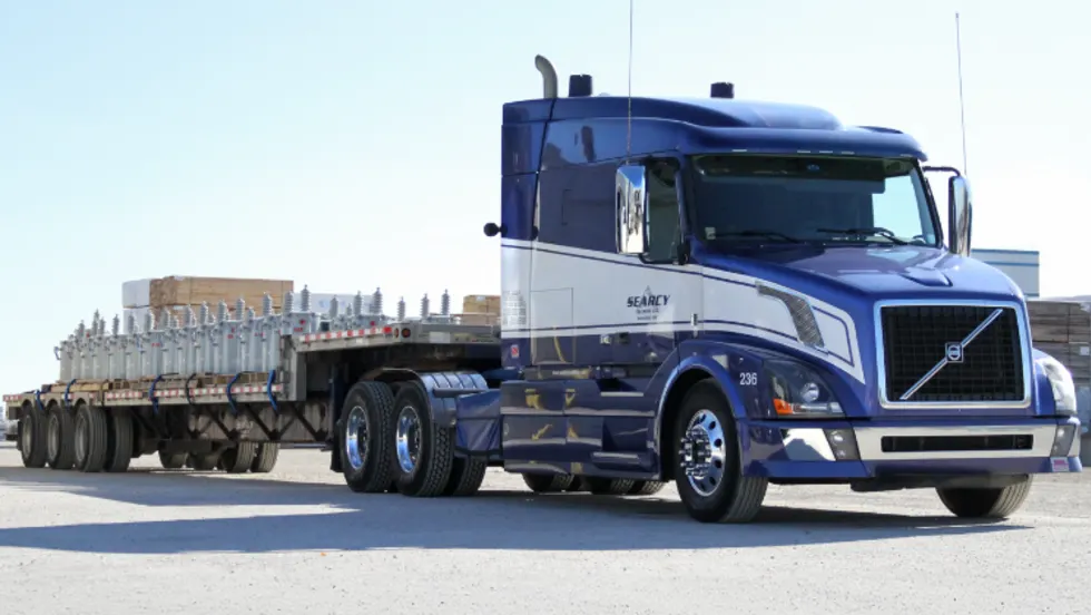 Photo of a Searcy truck pulling an open deck trailer