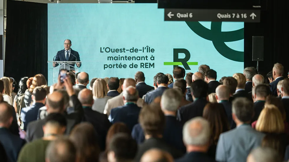 A man stands at a podium in front of a large crowd.
