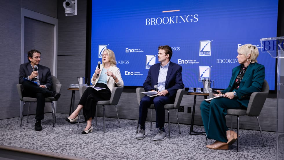 A panel of four people sitting on a stage.