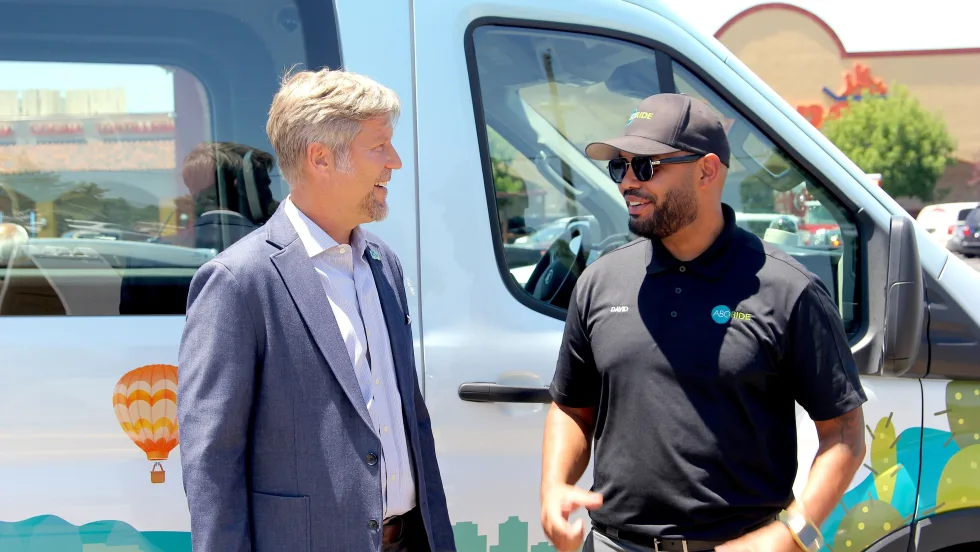 Mayor Tim Keller in front of an ABQ RIDE microtransit vehicle