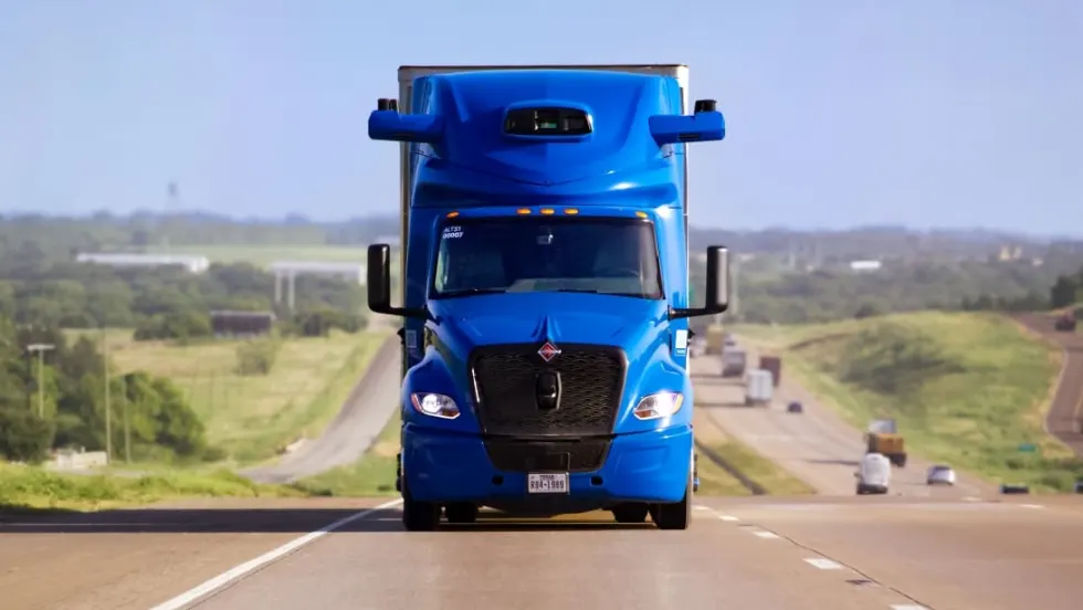 Blue International heavy-duty truck with Aurora driverless truck software coming head-on on an interstate highway