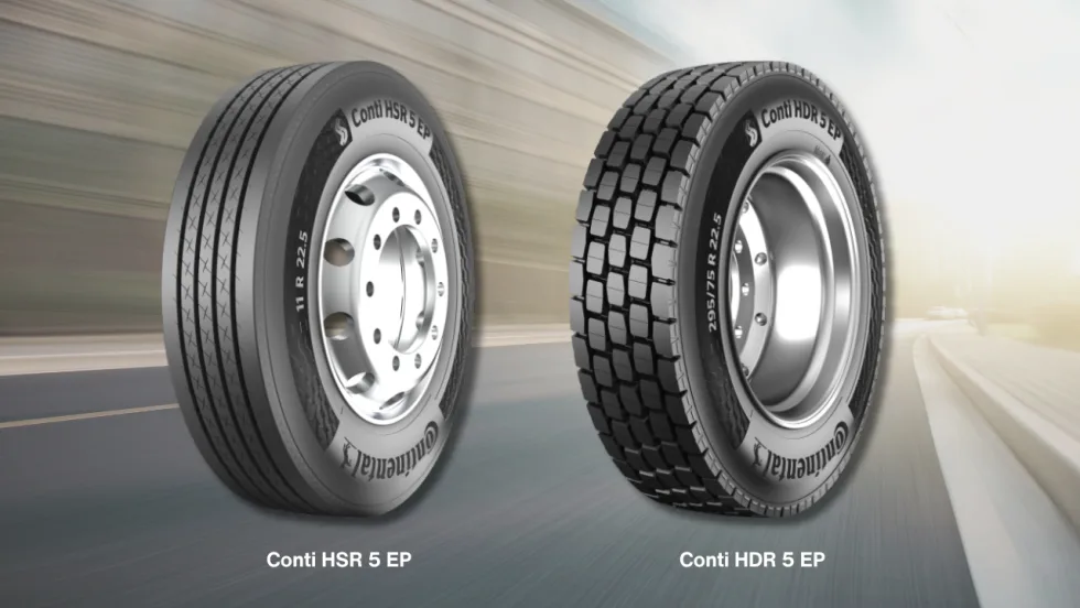Two truck tires with a muted highway background