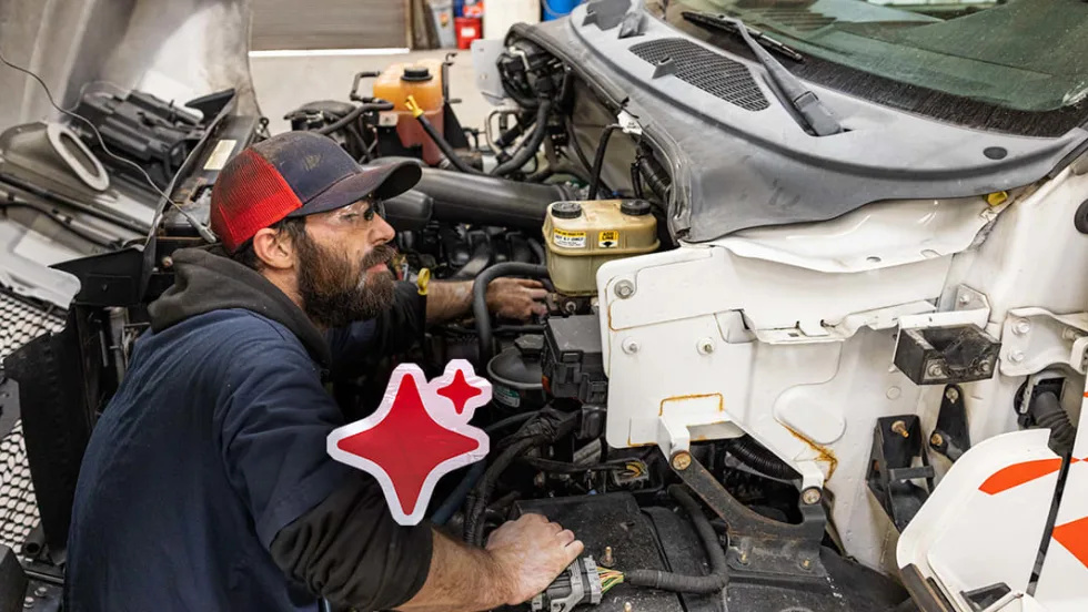 A man working on a truck engine.