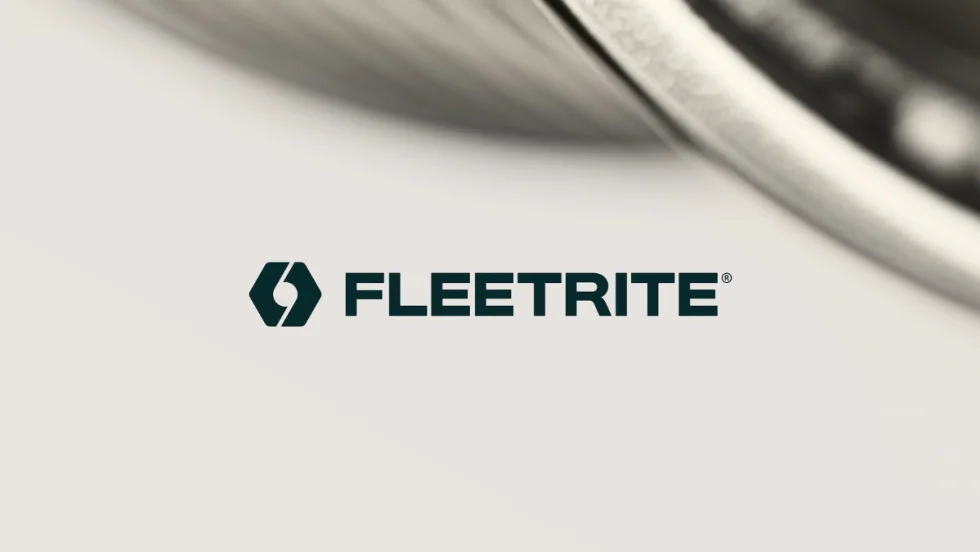 Fleetrite logo displayed against a light background with a blurred close-up of a vehicle in the upper right corner.