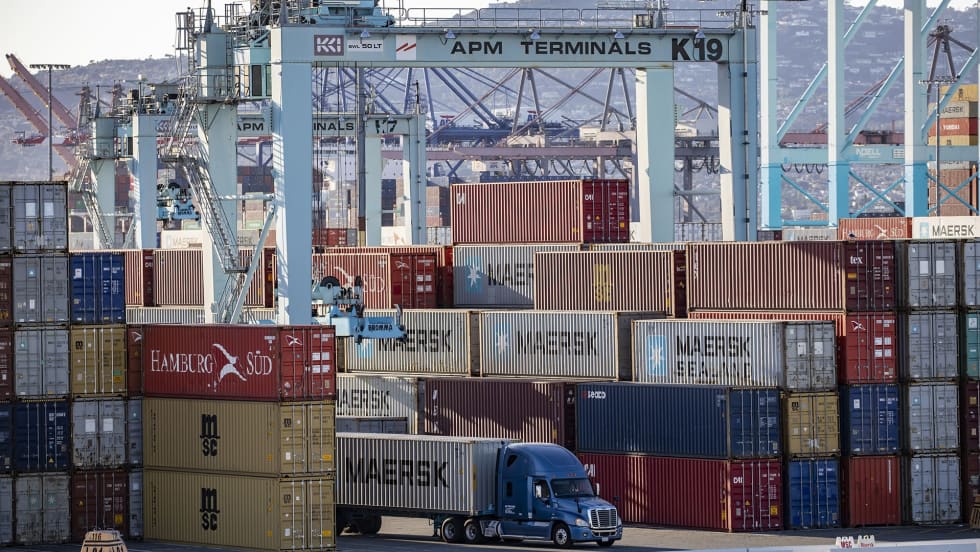 Stacks of intermodal containers at port with truck driving between them