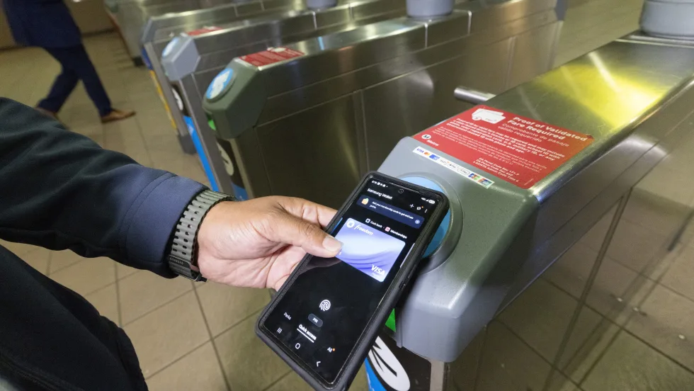 A person tapping their mobile card to ride LA Metro