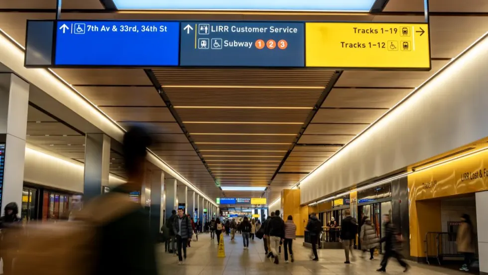 Image of Penn Station with people walking through the hallway.