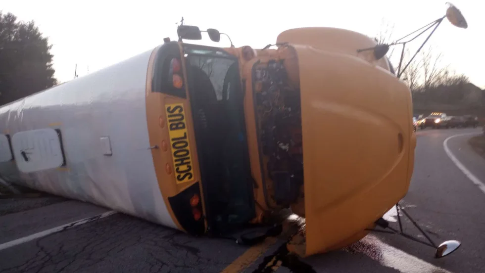 an overturned school bus on a roadway after an accident