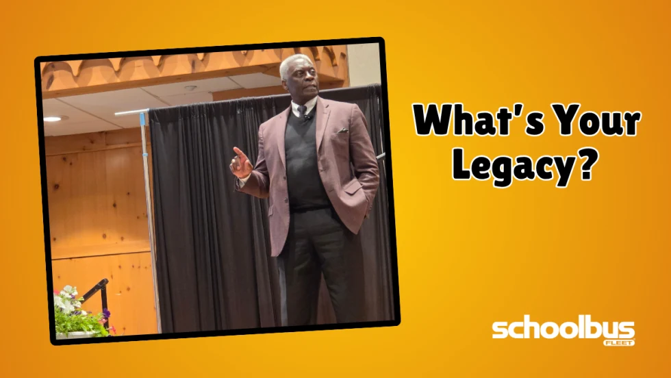 Nathanial “Coach” Hearne speaks onstage at a school transportation conference beside the words “What’s Your Legacy?” in a School Bus Fleet graphic.