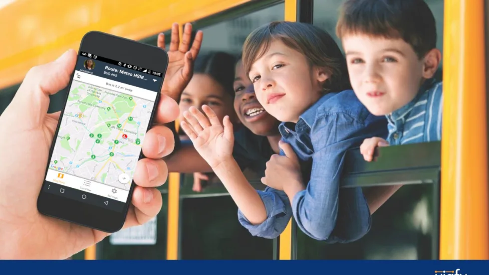 Students waving outside a bus window with an overlay of a hand holding a phone with a transportation tracking app open.