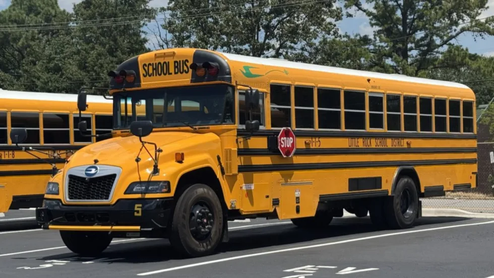 A yellow Little Rock School District school bus in a parking spot.