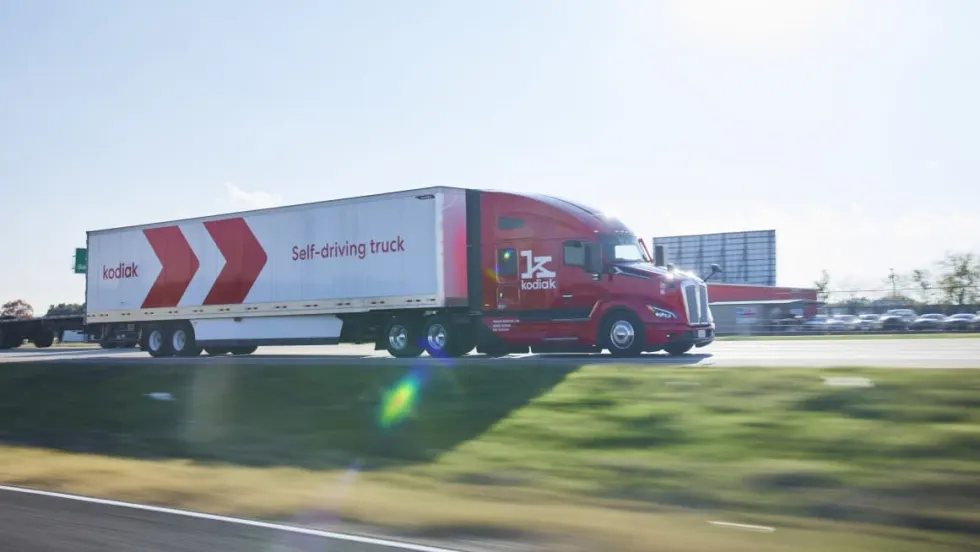 Red highway tractor pulling white trailer with red logo identifying Kodiak.