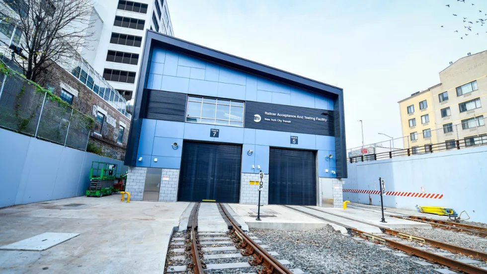 Exterior view of the Railcar Acceptance and Testing Facility with tracks leading into the closed bay doors.