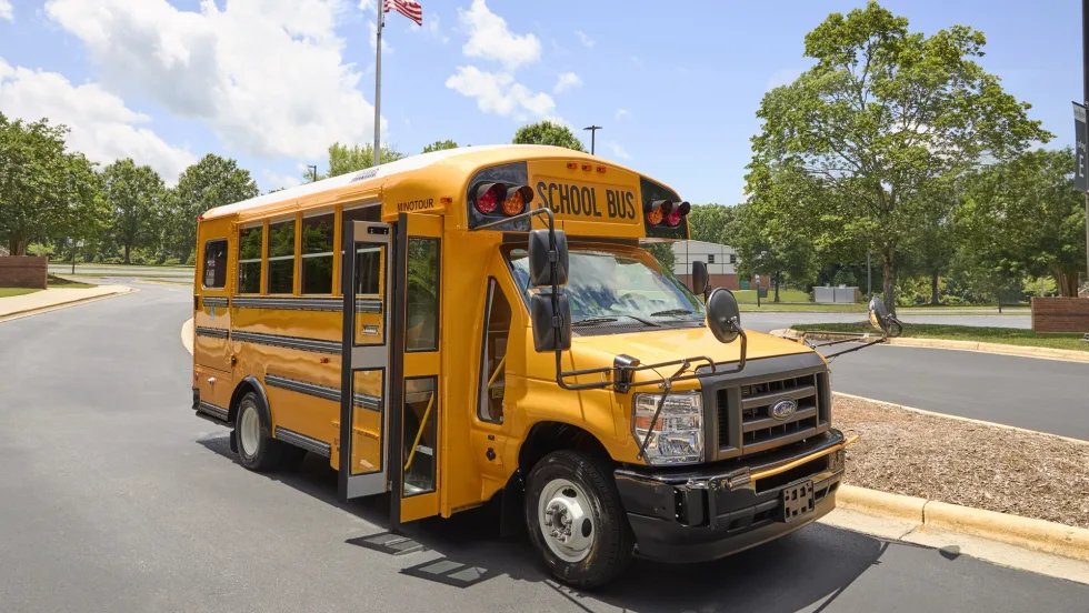 a thomas built type a minotour school bus is shown parked outside on a sunny day