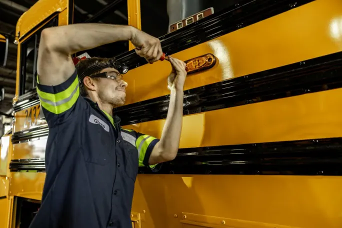 Technician adding lights to a school bus