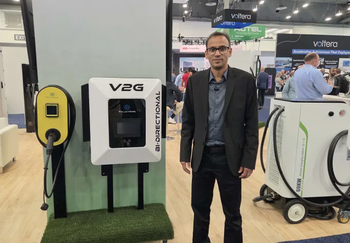 A Tellus Power rep stands next to the company's EV chargers