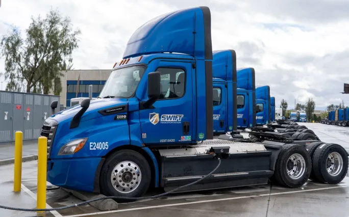 Blue Swift electric trucks at charging stations