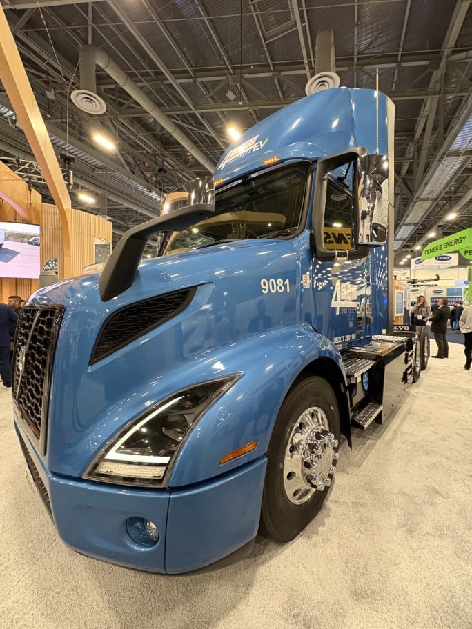 Blue volvo electric truck at a show booth with 4Gen logo on door