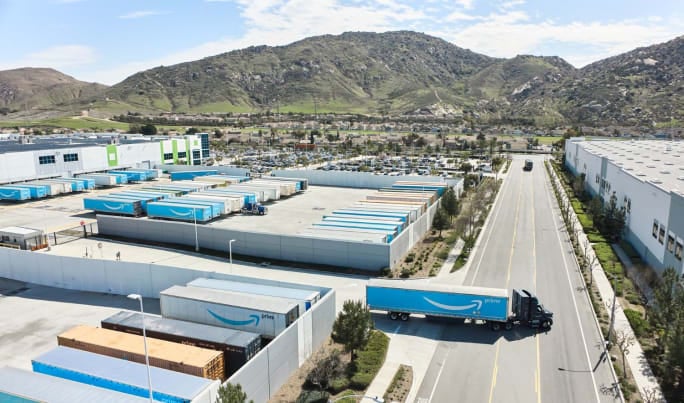 Amazon tractor-trailer pulling out from between warehouses shot from above