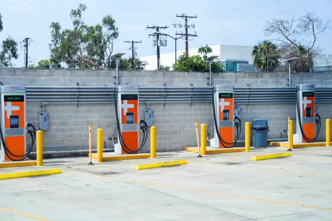 Charging infrastructure in front of a concrete wall.