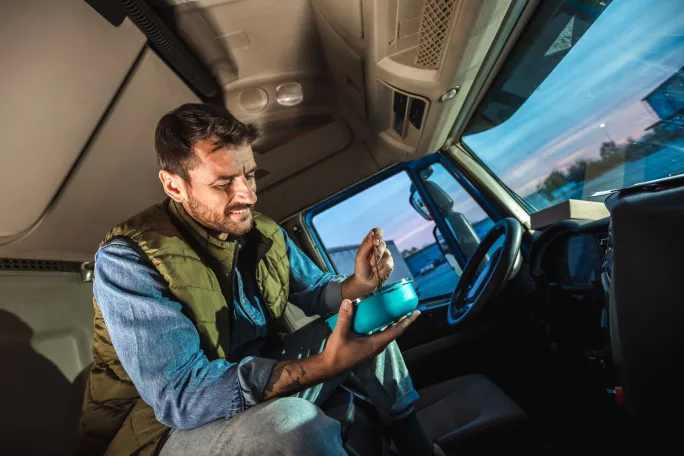 Trucker eating in the cab.