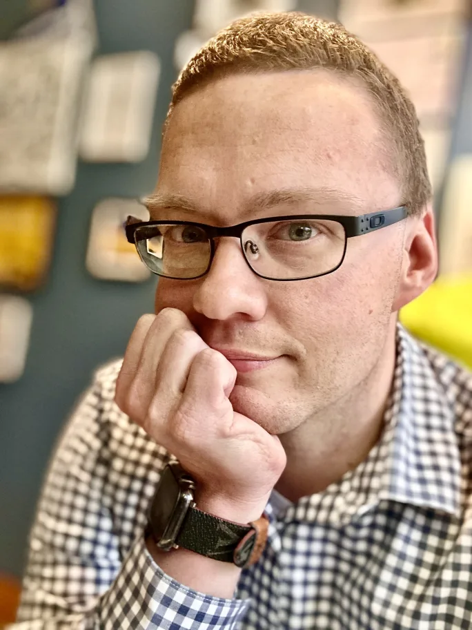 Joshua Baran sits with his hand on his chin at a desk