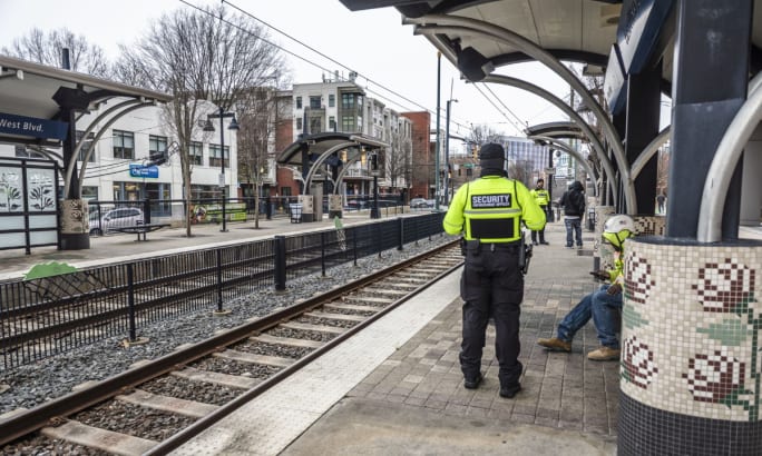 CATS See-Say officers stand on a light rail platform.