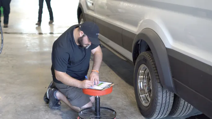 A maintenance official inspecting tires.